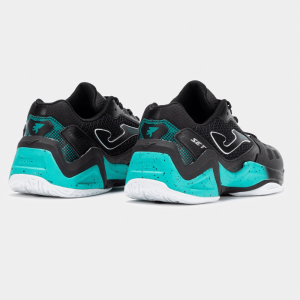 Pair of black and teal sneakers on a light gray background
