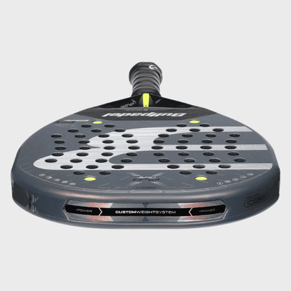 A close-up of a Papadopoulos C65 pickleball paddle face, showing the perforated carbon fiber pattern, custom light system, and part of the black grip against a light gray background.